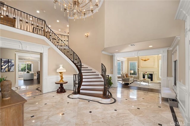 entryway with an inviting chandelier and crown molding