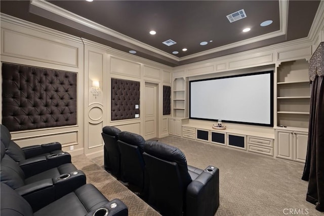 carpeted home theater room with ornamental molding and built in features