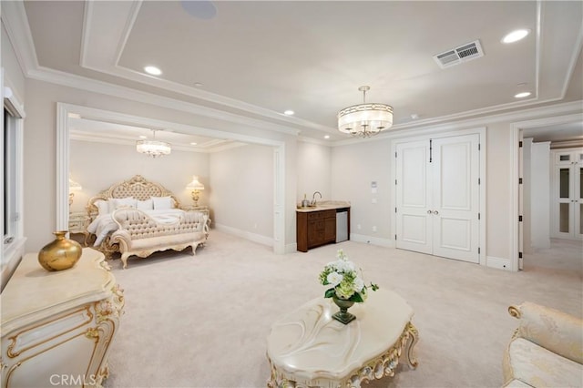 carpeted bedroom featuring a tray ceiling, sink, crown molding, and a chandelier