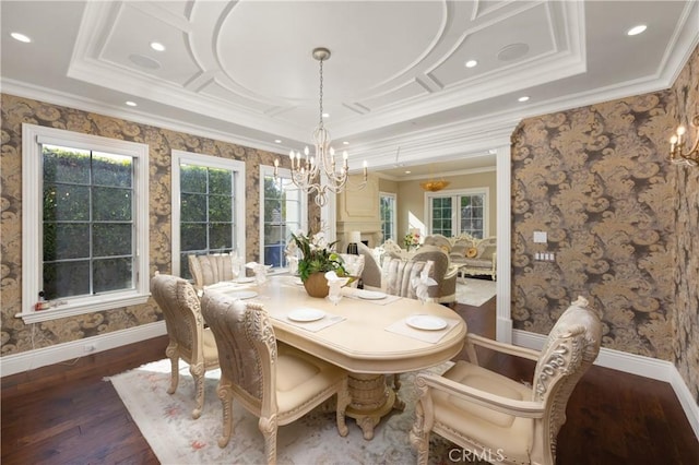 dining area with dark wood-type flooring, a raised ceiling, crown molding, and a notable chandelier