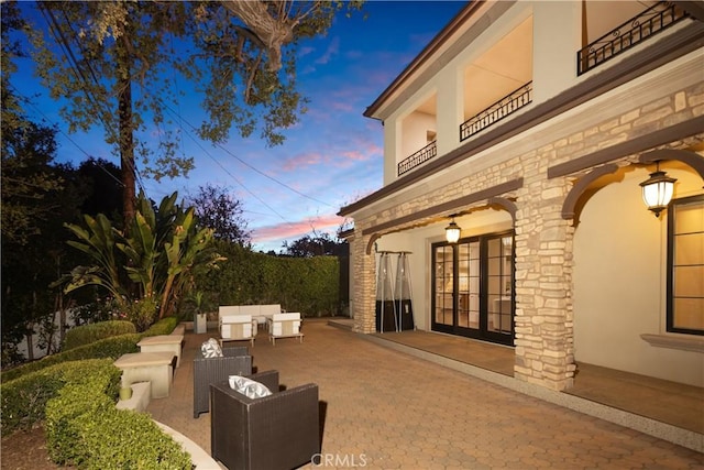 patio terrace at dusk featuring an outdoor hangout area and french doors