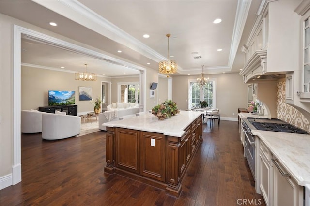 kitchen with high end range, a kitchen island, a wealth of natural light, hanging light fixtures, and light stone countertops