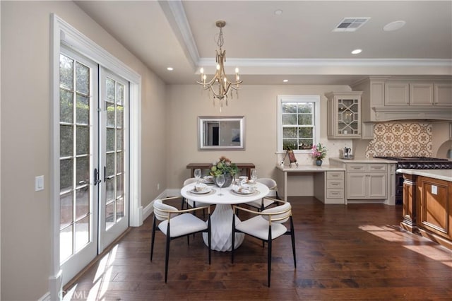 dining area featuring french doors, a notable chandelier, ornamental molding, and dark hardwood / wood-style floors