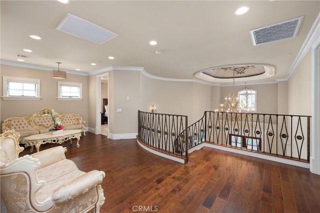 interior space with an inviting chandelier, dark hardwood / wood-style flooring, ornamental molding, and a raised ceiling