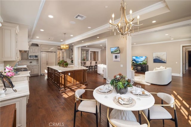 dining space with a chandelier, dark wood-type flooring, a tray ceiling, and ornamental molding