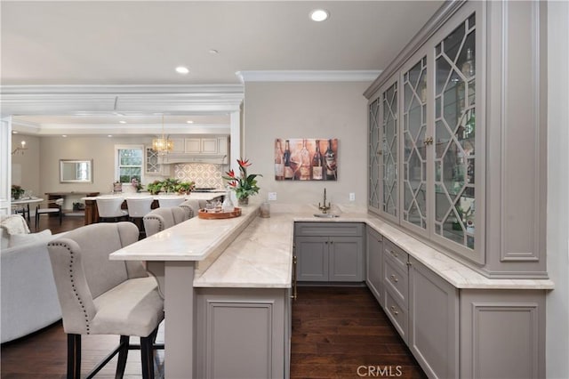 bar with crown molding, sink, pendant lighting, and gray cabinets