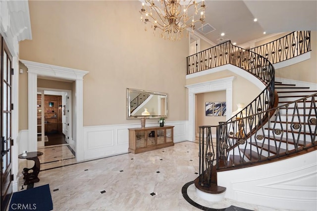 entryway featuring an inviting chandelier and a towering ceiling