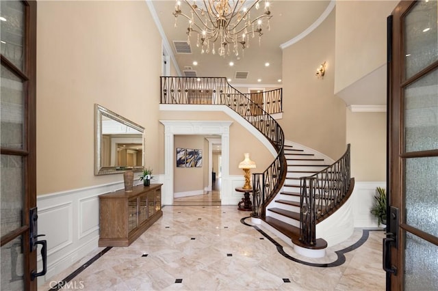 foyer featuring ornamental molding and an inviting chandelier