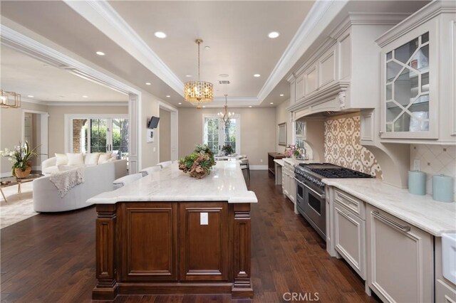 kitchen with decorative light fixtures, range with two ovens, decorative backsplash, and a kitchen island