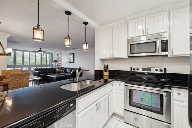 kitchen featuring appliances with stainless steel finishes, decorative light fixtures, sink, and white cabinets