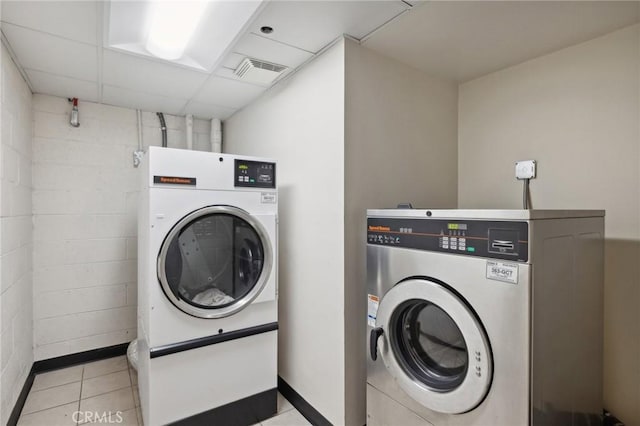 common laundry area featuring washing machine and dryer, visible vents, and light tile patterned flooring