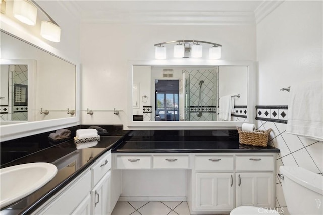 bathroom with double vanity, tile walls, toilet, crown molding, and a sink