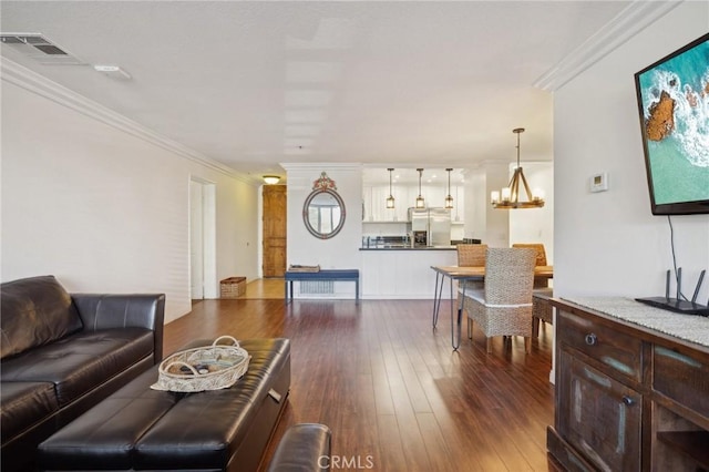 living area with a notable chandelier, dark wood-style flooring, visible vents, and crown molding