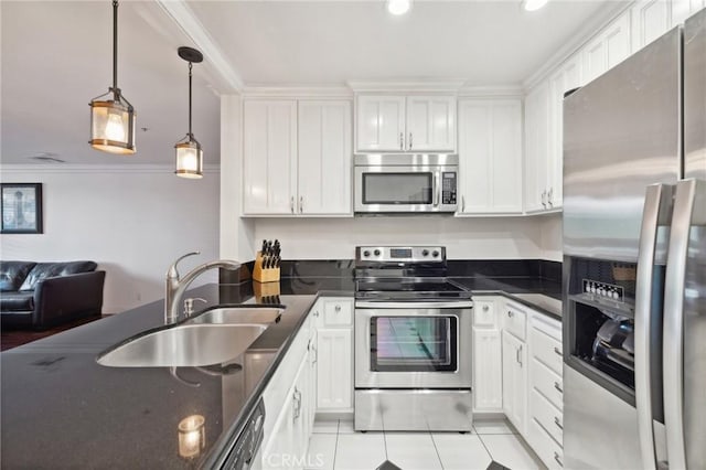 kitchen with dark countertops, stainless steel appliances, a sink, and hanging light fixtures