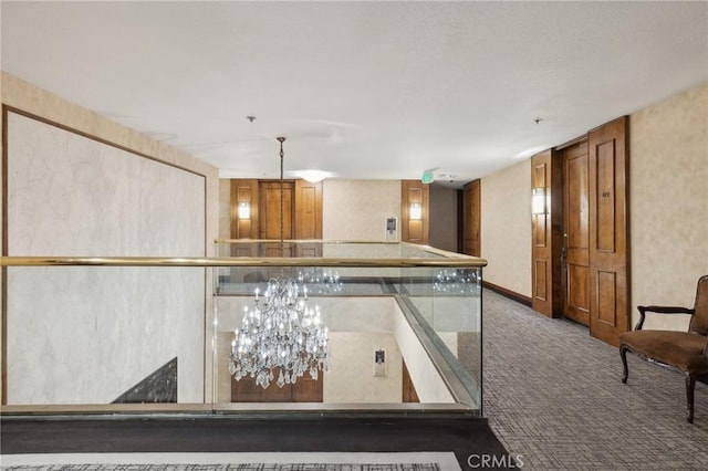 kitchen featuring dark colored carpet and hanging light fixtures