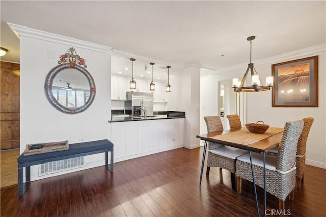 dining area featuring dark wood-style floors, a chandelier, visible vents, and ornamental molding