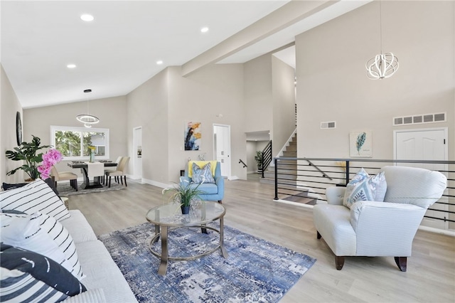 living room featuring a notable chandelier, light wood-type flooring, and high vaulted ceiling