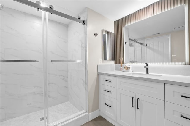 bathroom with hardwood / wood-style floors, vanity, and a shower with shower door