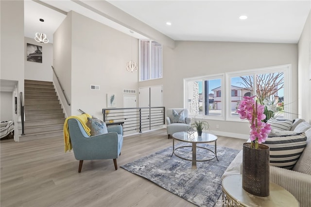 living room featuring high vaulted ceiling and light wood-type flooring