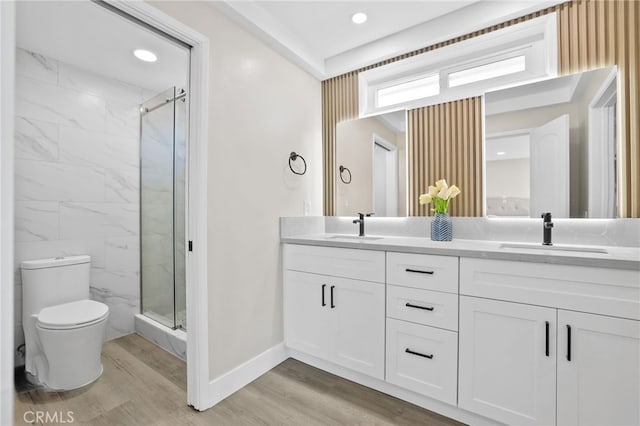 bathroom with vanity, hardwood / wood-style flooring, toilet, and an enclosed shower