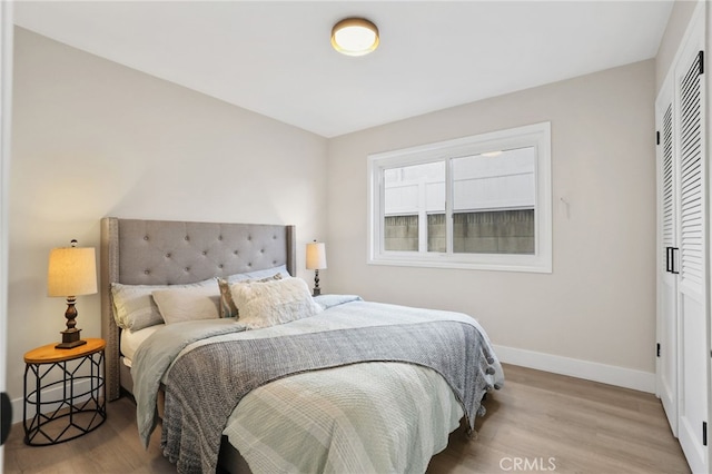 bedroom with light hardwood / wood-style flooring and a closet