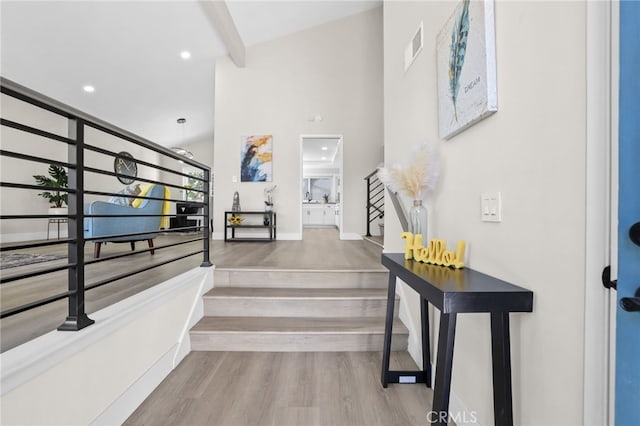 staircase featuring hardwood / wood-style floors and vaulted ceiling