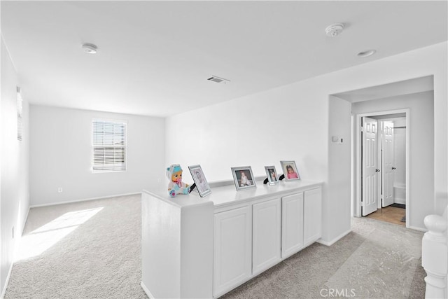 interior space featuring light carpet and white cabinetry