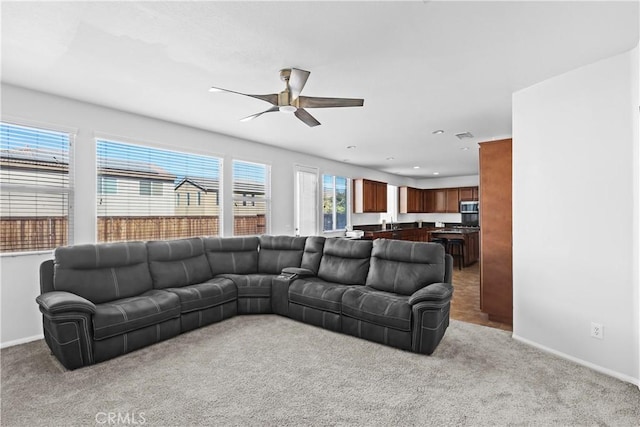 carpeted living room with ceiling fan