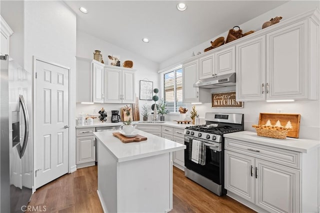 kitchen featuring white cabinets, hardwood / wood-style floors, a kitchen island, and appliances with stainless steel finishes