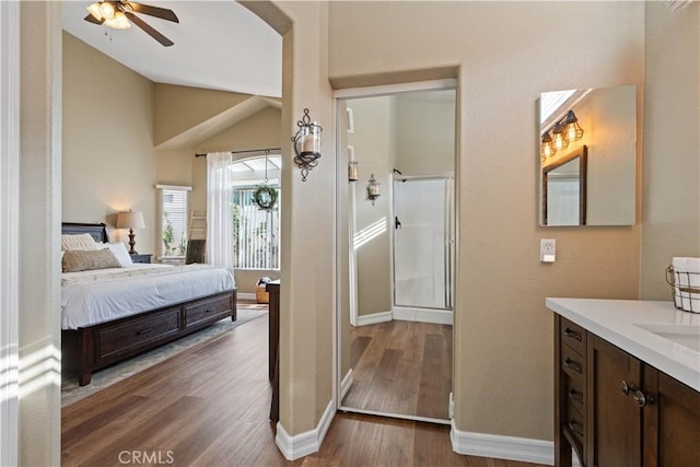 bedroom with vaulted ceiling, ceiling fan, and dark wood-type flooring