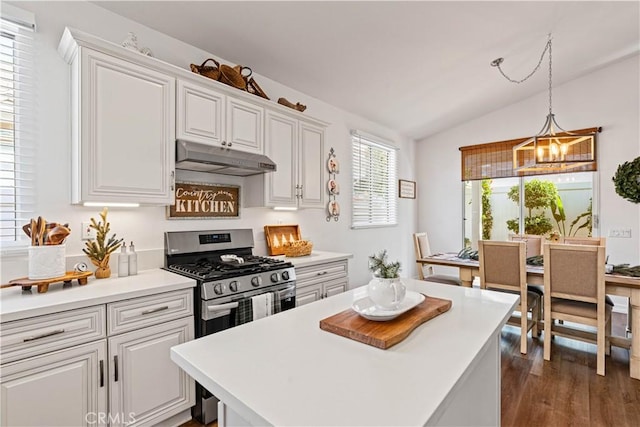 kitchen featuring white cabinets, dark hardwood / wood-style floors, lofted ceiling, and gas range