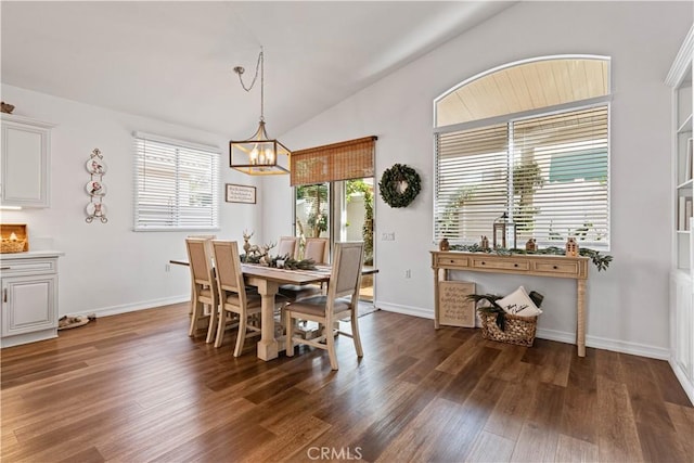 dining area with dark hardwood / wood-style flooring, lofted ceiling, and a chandelier