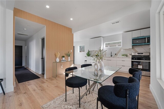 dining area featuring sink and light hardwood / wood-style floors