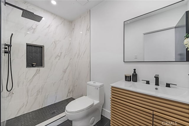 bathroom with vanity, tiled shower, tile patterned floors, and toilet