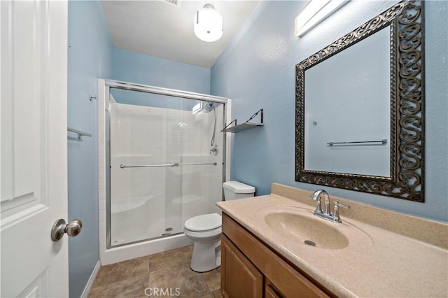 bathroom featuring an enclosed shower, vanity, tile patterned floors, and toilet