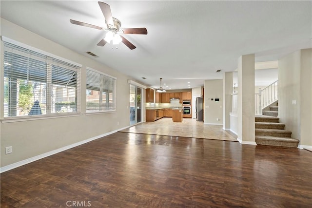 unfurnished living room featuring light wood-type flooring and ceiling fan