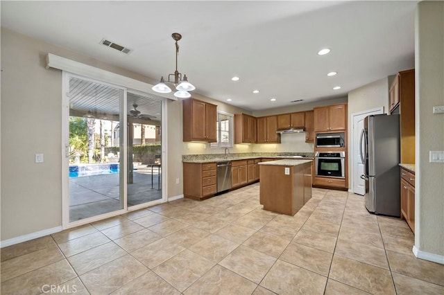 kitchen with light tile patterned floors, stainless steel appliances, hanging light fixtures, a kitchen island, and sink