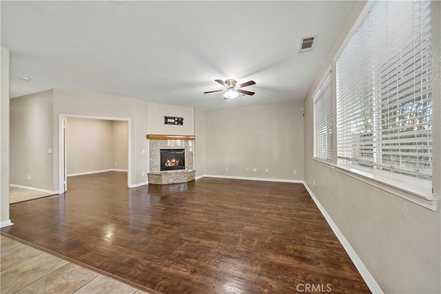 unfurnished living room featuring ceiling fan and dark hardwood / wood-style flooring