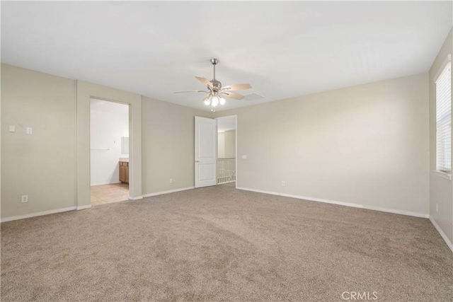 unfurnished bedroom with ceiling fan, light colored carpet, and connected bathroom