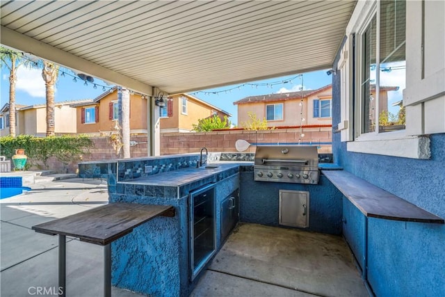 view of patio featuring a grill, an outdoor kitchen, and a wet bar