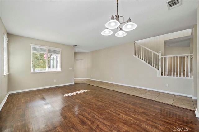 unfurnished room featuring dark hardwood / wood-style floors and a chandelier