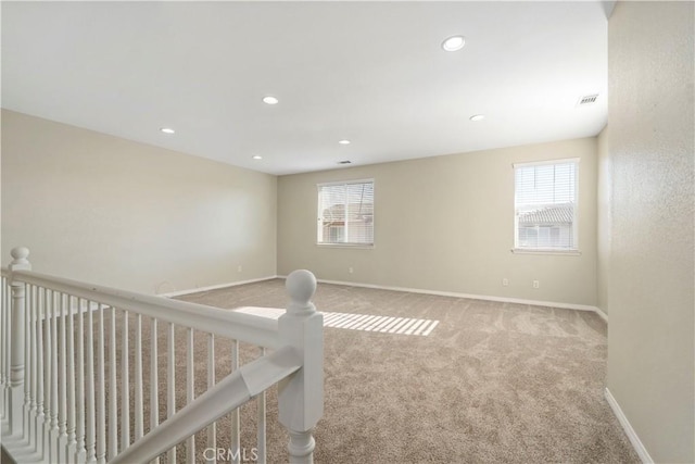 spare room featuring light carpet and a wealth of natural light