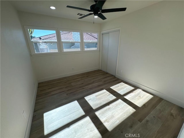 unfurnished room featuring ceiling fan and dark hardwood / wood-style flooring