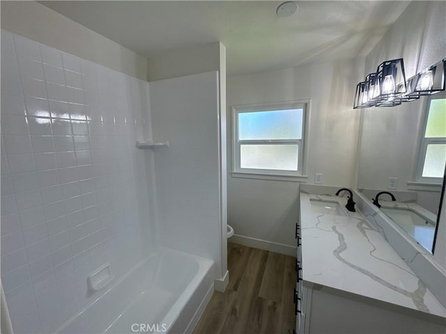 full bathroom with washtub / shower combination, hardwood / wood-style floors, toilet, and vanity