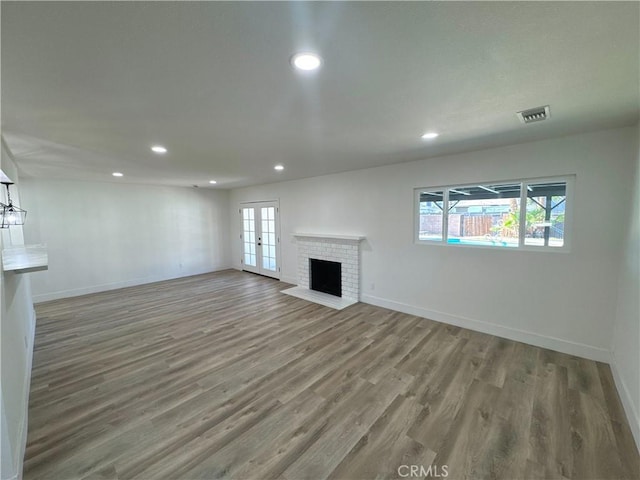 unfurnished living room with hardwood / wood-style floors and a fireplace