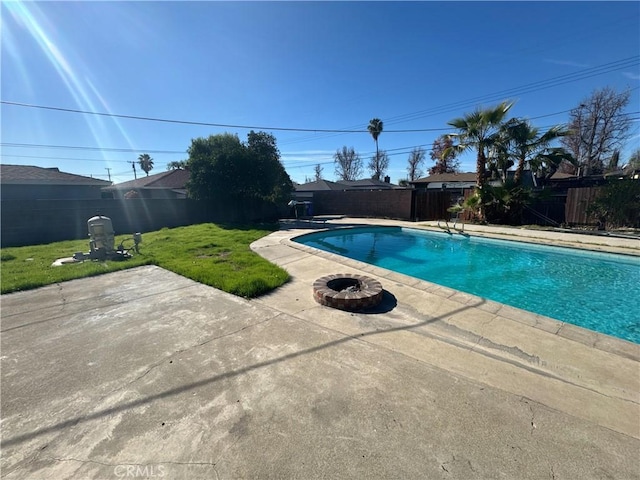 view of swimming pool featuring a patio area, an outdoor fire pit, a yard, and a diving board