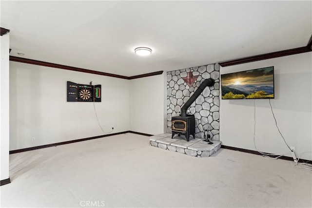 basement with a wood stove, crown molding, and carpet