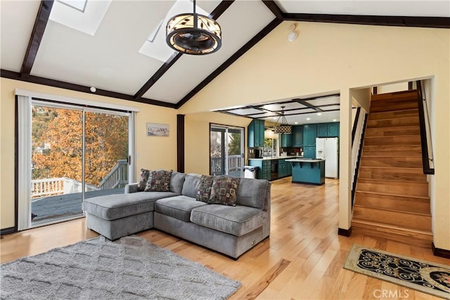 living room with beamed ceiling, high vaulted ceiling, a wealth of natural light, and light hardwood / wood-style flooring