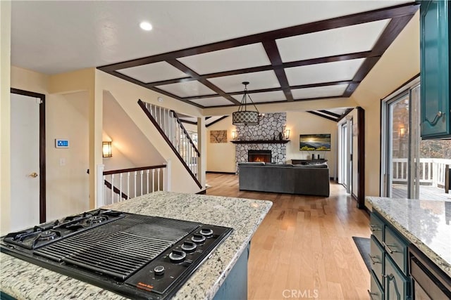 918 Sandalwood Dr, Lake Arrowhead, CA 92352 - kitchen with stovetop with downdraft, coffered ceiling, a fireplace, light wood-style floors, and light stone counters