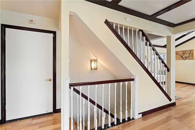 stairs featuring beamed ceiling and wood-type flooring